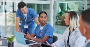 A nurse leader discusses patient care with her medical team.